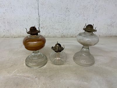 Three Glass Kerosene Oil Lamps with Burners. Three kerosene oil lamps made of clear and amber 