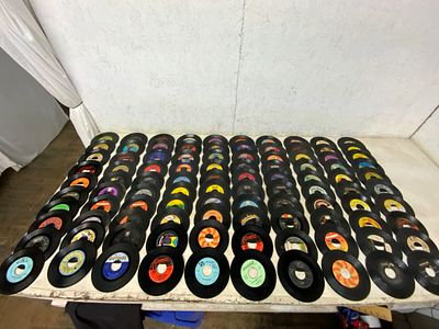 100 Vinyl 45 RPM Records. 100 assorted 45 RPM vinyl records featuring various labels and genres. 