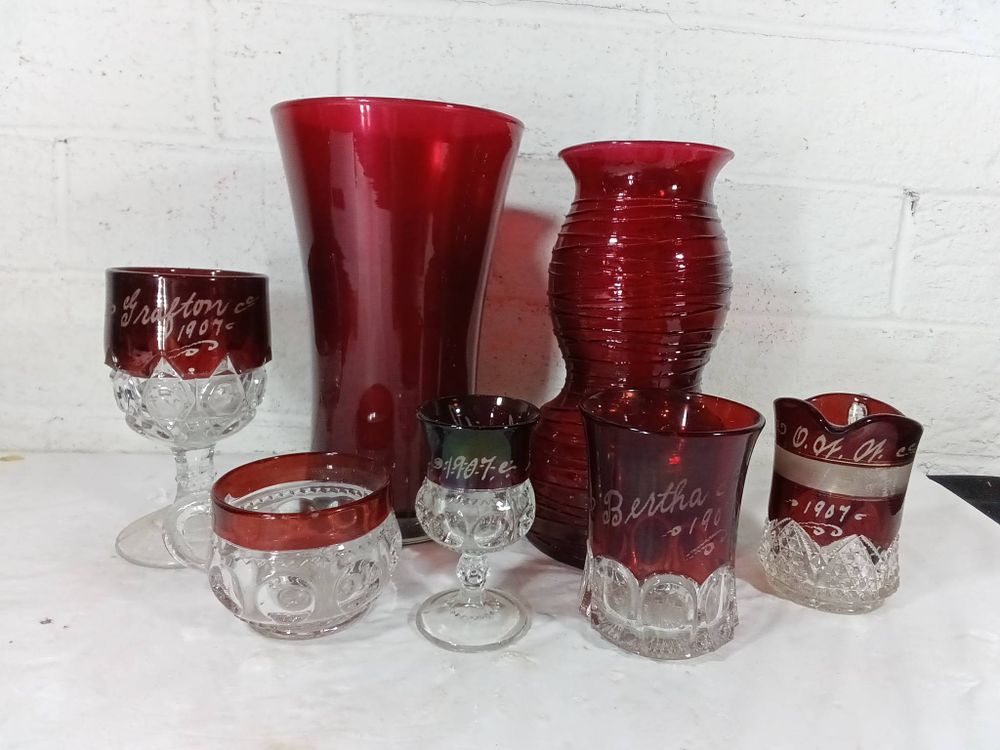 Red Glass Vessels with Etching. Seven red glass vessels, including vases and goblets, many 