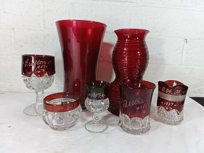 Red Glass Vessels with Etching. Seven red glass vessels, including vases and goblets, many 