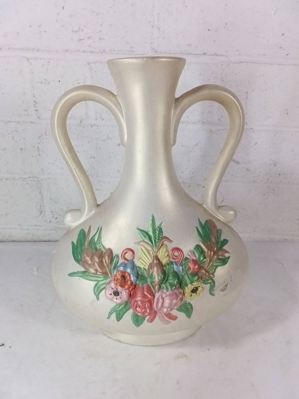Double-Handled Pottery Vase with Floral Motif. A pottery vase featuring a double-handled design 