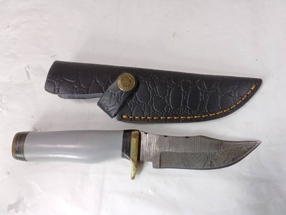 Damascus Steel Knife with Sheath. Damascus steel knife featuring a patterned blade indicative of 