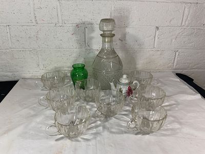 Glass Decanter with Cups and Decorative Items. Glassware set featuring a clear glass decanter 