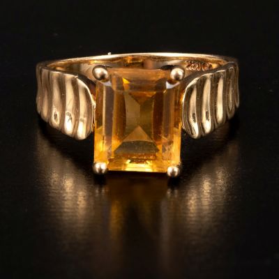 A 14K Yellow Gold and Citrine Ring. containing one emerald cut yellow citrine quartz measuring 