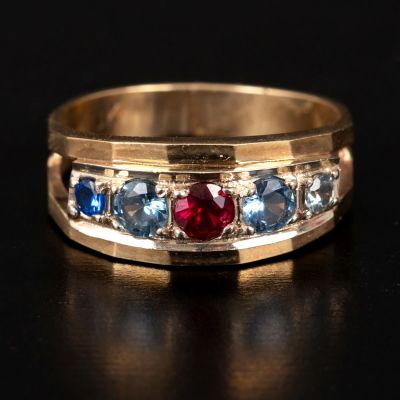 A 10K Yellow Gold and Gemstone Ring. containing 5 red and blue gemstones set in a straight line. 