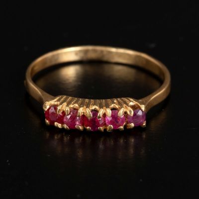 14 karat gold ring set with five rubies. A 14 karat yellow gold hoop ring set with five rubies. 