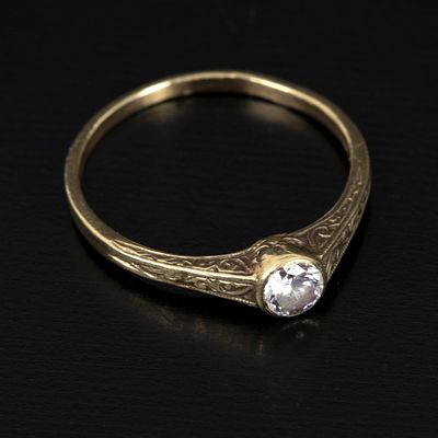 Vintage 14K Yellow Gold . with hand carved filigree details, containing one round brilliant cut 