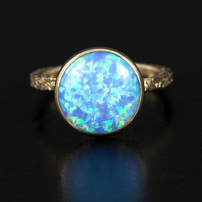 9 Karat Yellow Gold and Opal Ring. a lovely design containing one round cabochon cut opal 