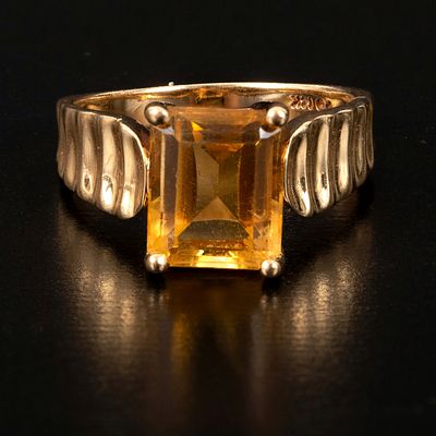 A 14K Yellow Gold and Citrine Ring. containing one emerald cut yellow citrine quartz measuring 