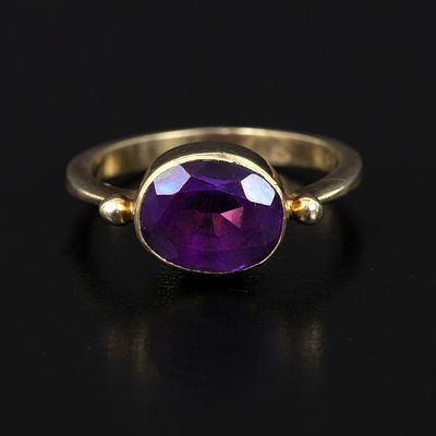 Vintage 14K Yellow Gold and Amethyst Ring. containing one bezel set oval shape mixed cut 