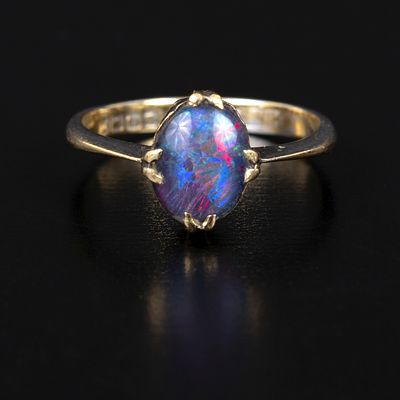 Vintage 18K Gold and Opal Ring. solitaire style ring containing one oval shape cabochon cut opal 