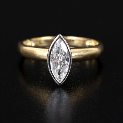 18K Gold and Diamond Solitaire Ring. white gold bezel on a yellow gold ring, containing one 