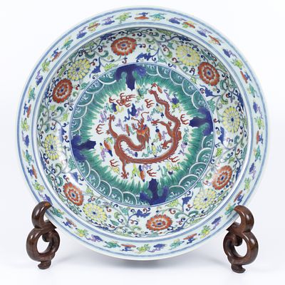 An old Chinese porcelain plate decorated with a colorful painting. Hand painted in a scene with 