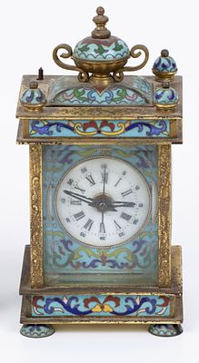 An old Victorian traveling clock decorated with enamel paintings. The movement was changed to a 