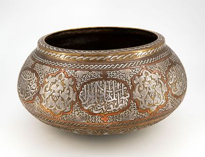 קערה דמשקאית גדולה מפליז בשיבוץ כסף ונחושת, תחילת המאה ה-20. גוף פקעתי מפליז משובץ עורקי כסף 