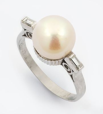 טבעת אר-דקו מפלטינה פנינה ויהלומים. משובצת במרכזה בפנינה בשילוב שני יהלומים בליטוש באגט בצדדיה. 