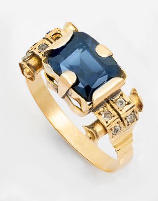 טבעת רטרו מזהב צהוב 14 קראט ואבני חן. משובצת במרכזה באבן חן כחולה בשילוב אבני חן שקופות. זהב 