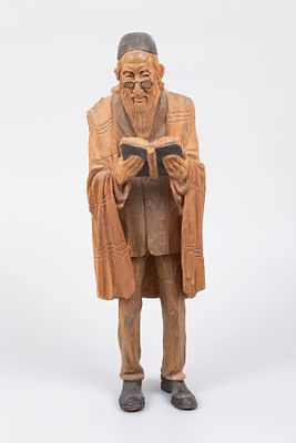 A Carved Wood Figurine of a Praying Jew circa 1900. Depicting a standing male figure wrapped in 