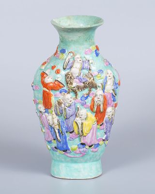 An Antique Porcelain Vase, China. Decorated in relief with the Immortals and a dragon. Signed. 