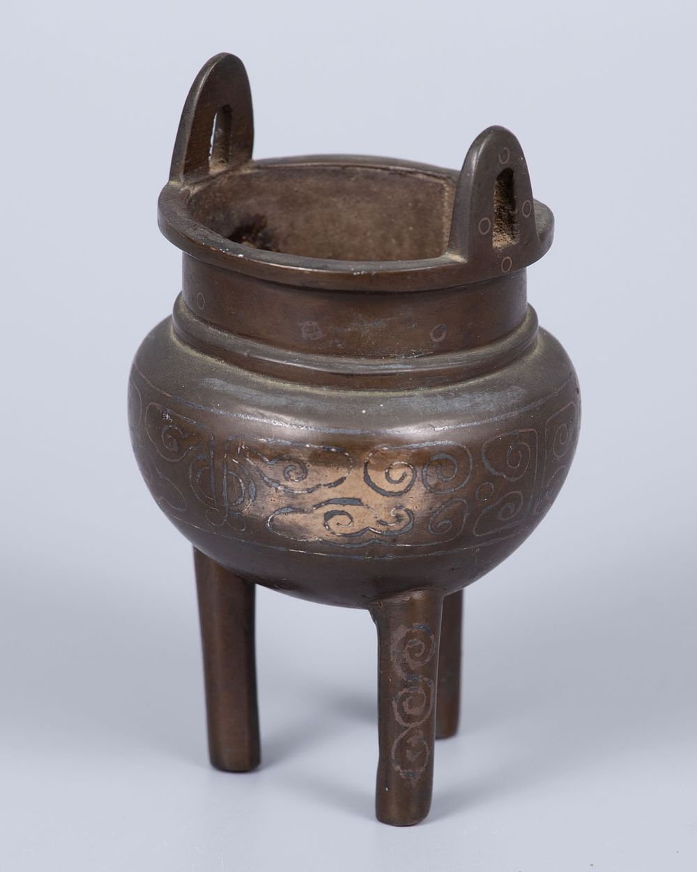 A Bronze and Silver Inlay Censer, China, Qing Dynasty (1644–1912). In tripod form, inlaid with 