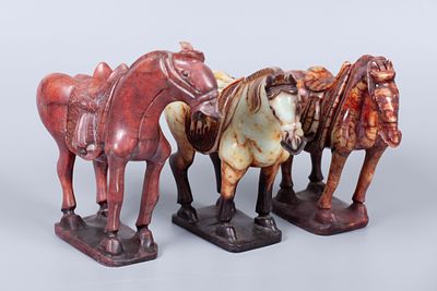 A Group of Three Carved Russet Jade Horse Figures, China. Carved as three standing horse figures 