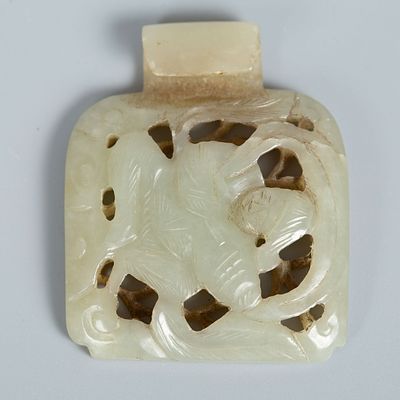 An Old Carved Celadon Jade Belt Buckle, China. A belt buckle carved from celadon jade in a pale 
