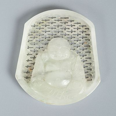 A Carved White Jade Buddha Plaque. The background features an openwork lattice pattern. The 