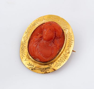 An 18K Gold and Coral Cameo Brooch, Italy, 19th Century. Designed as an oval carved coral cameo 