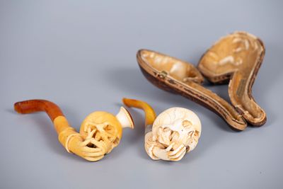 A Pair of Carved Amber and Meerschaum Pipes, 19th Century. Comprising two pipes: 
1. A memento 