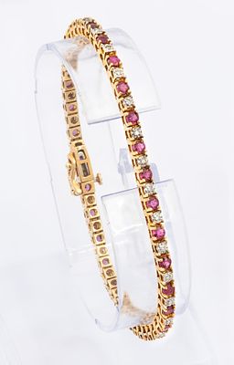 A 14K Yellow and Gold ruby and Diamond Tennis Bracelet. Set with 30 pink 
ruby stones (approx. 