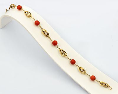 A Fine 18K Yellow Gold and Coral Bead Bracelet. Composed of stylized hollow oval elements 
