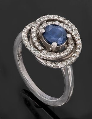 A Fine 14K White Gold Diamond and Sapphire Ring. The head centered by a round-cut sapphire 