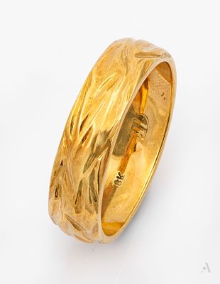 A Stylized 18K Yellow Gold Wedding Ring. Decorated with grooved motifs. Marked and gold acid 