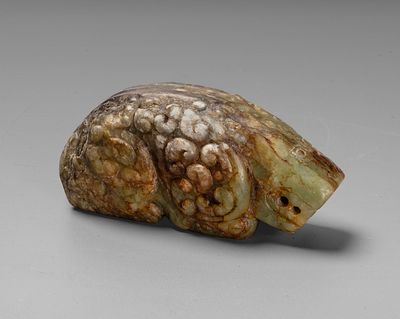 An Archaic Chinese Carved Jade Figurine of a Recumbent Mythical Beast. With a compact body and 