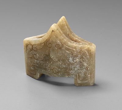 An Archaic Carved Jade Sword Guard, China, Han Dynasty. Carved from greenish-grey jade, of 