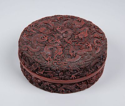 A Chinese Carved Cinnabar style Box and Cover. Of rounded form, densely carved with writhing 