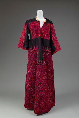 An Embroidered Dress, Palestine, Early 20th Century. Of black fabric with red side panels and 