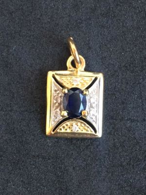 תליון זהב צהוב 14K עם עבודת רודיום וזירקונים. משובץ אבן ספיר טבעית במשקל של כ- 0.30 קראט. 