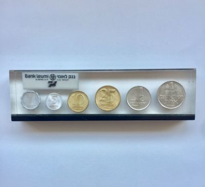 סט מטבעות ישראל תשל"ו בתוך משקולת נייר לשולחן משרדי של בנק לאומי.