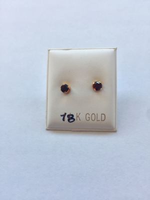 זוג עגילי זהב 18K. משובצים אבני גרנט. 
סוגר סיליקון נצמד לאוזן. הפריט לא נמכר עפ"י משקל.