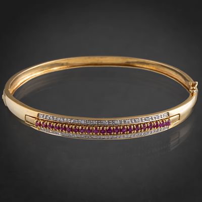 Bonita pulsera r&iacute;gida con banda de brillantes y rub&iacute;es en oro amarillo de 18 kt. Measurements: 