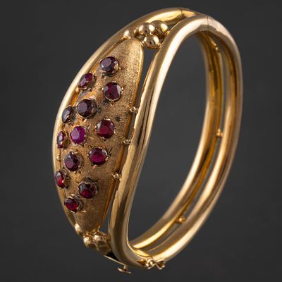 Pulsera r&iacute;gida en oro amarillo de 18kt con rub&iacute;es sint&eacute;ticos y granates. Measurements: 5 x 5,5 cms.