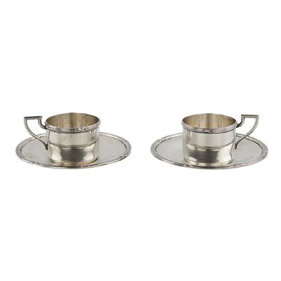 Silver coffee cups. Pair of silver coffee cups with saucers decorated with artistic 