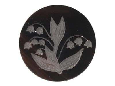 BLACK INTAGLIO CARVING LILY OF THE VALLEY FLOWERS. A black intaglio carving depicting a lily of 