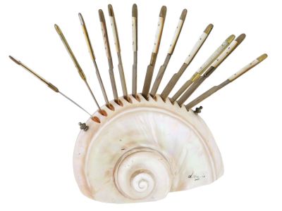 ANTIQUE BRASS PEARL KNIFE SET IN NAUTILUS SHELL HOLDER. An antique set featuring twelve brass 