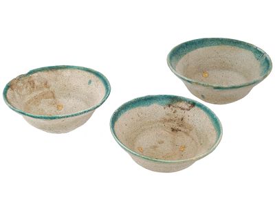 ANCIENT ISLAMIC GLAZED CLAY BOWLS WITH PAINTED EDGES. A group of three ancient Islamic glazed 