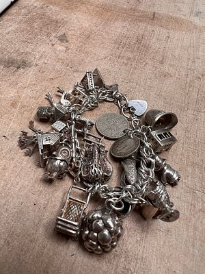 A HM silver charm bracelet with aprox 30 charms. 88g.