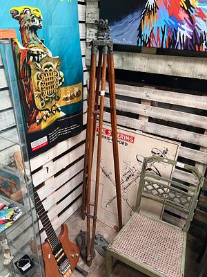 An early 20th century theodolite with wooden tripod base.