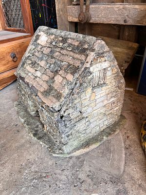 A miniature folk art garden model of a replica stone house. 42cm tall