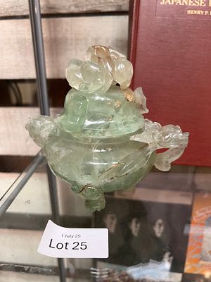 A Chinese stone carved lidded urn with twin dragon head handle and carved figural lid.